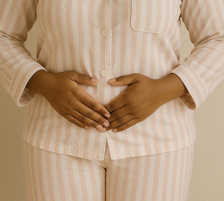 Woman gently holding her lower abdomen, representing the lived experience of endometriosis
